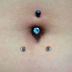 A navel with a vertical and a horizontal belly button piercing