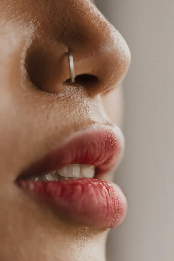 A woman's mouth and nose adorned with a nose ring