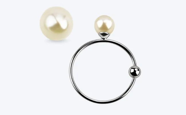 A surgical steel captive bead ring with a white pearl ball top