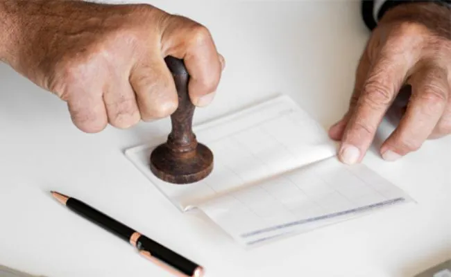 A document is being stamped using a wooden stamp