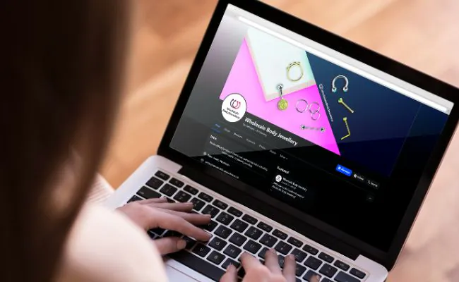 Image of a laptop that shows a piercing wholesalers Facebook business page used to improve jewellery sales
