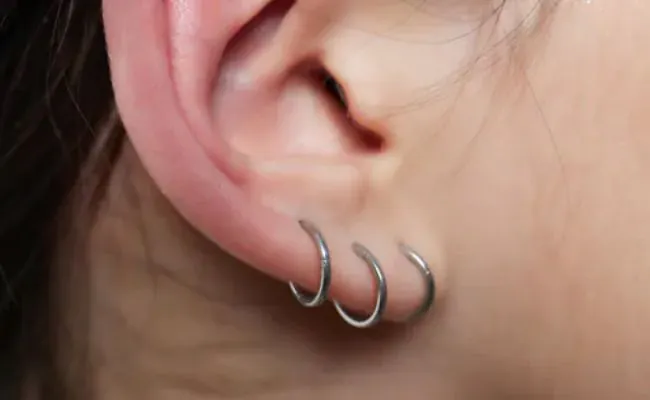 Closeup of an ear adorned with a stacked lobe piercing