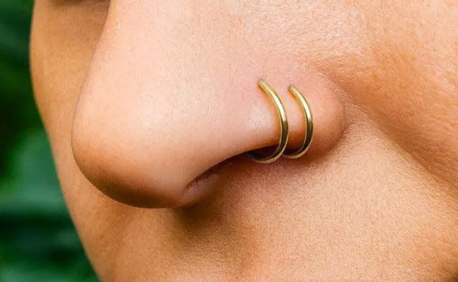 A nose adorned with two gold nose rings