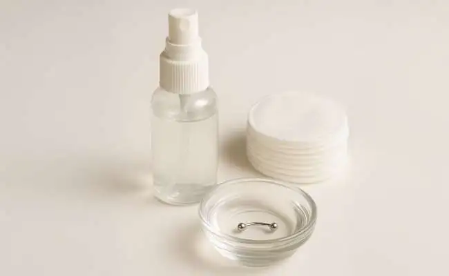 Various piercing aftercare supplies including saline solution and cotton pads